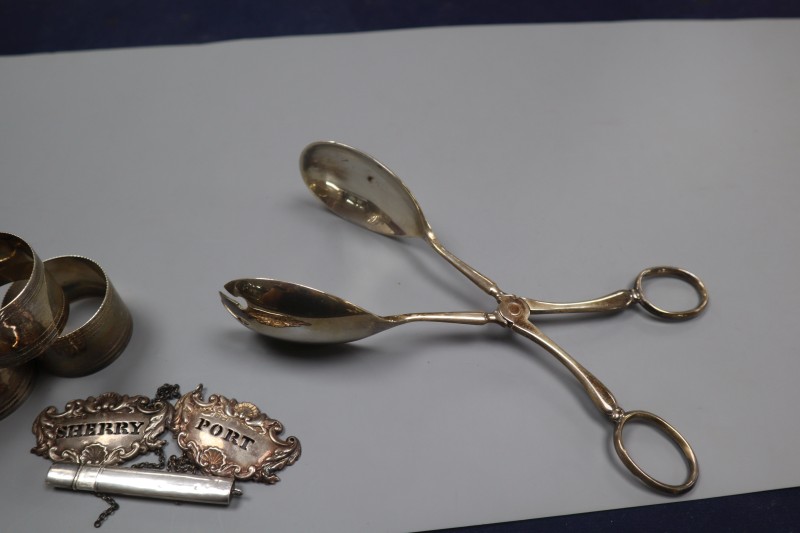 A pair of Victorian silver wine labels, pair of silver salad servers, pencil holder and six plated napkin rings.